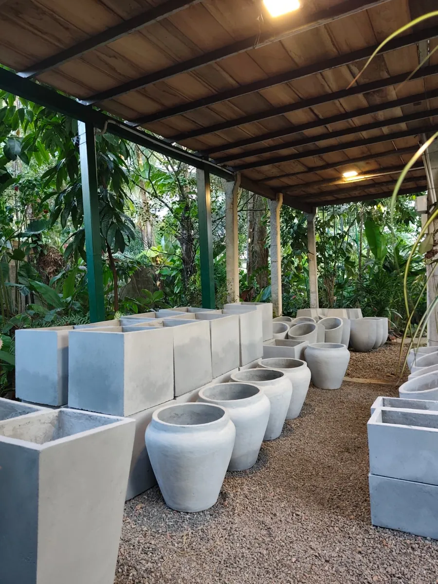 Round and rectangular titanium pots displayed beneath the covered nursery canopy at Heliconia Garden
